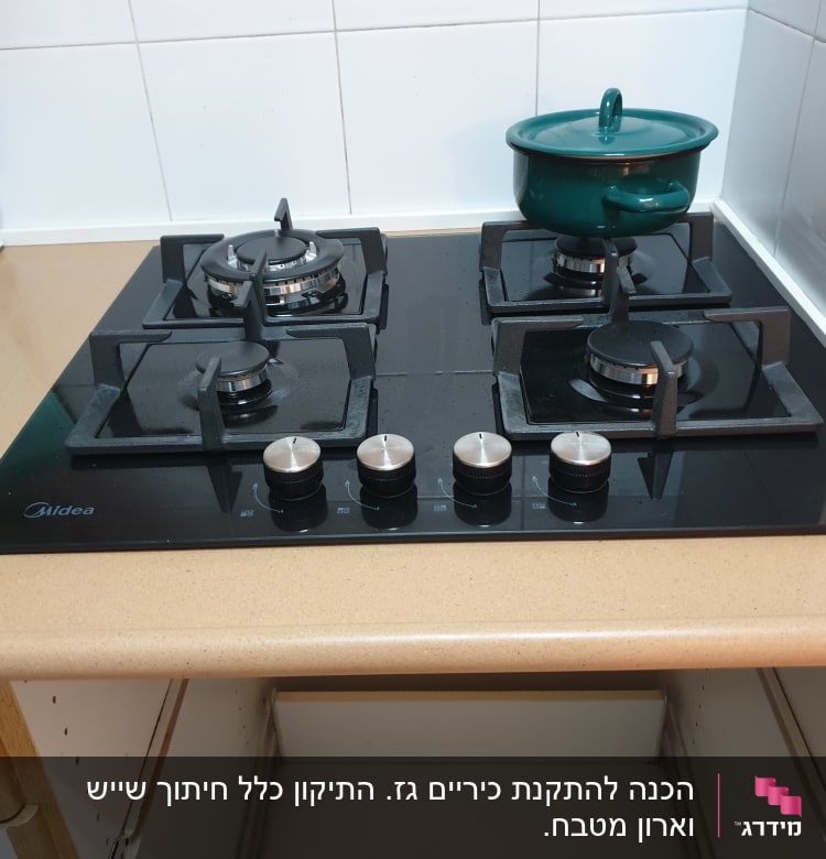 כיריים גז עם סיר ירוק על הכיריים
